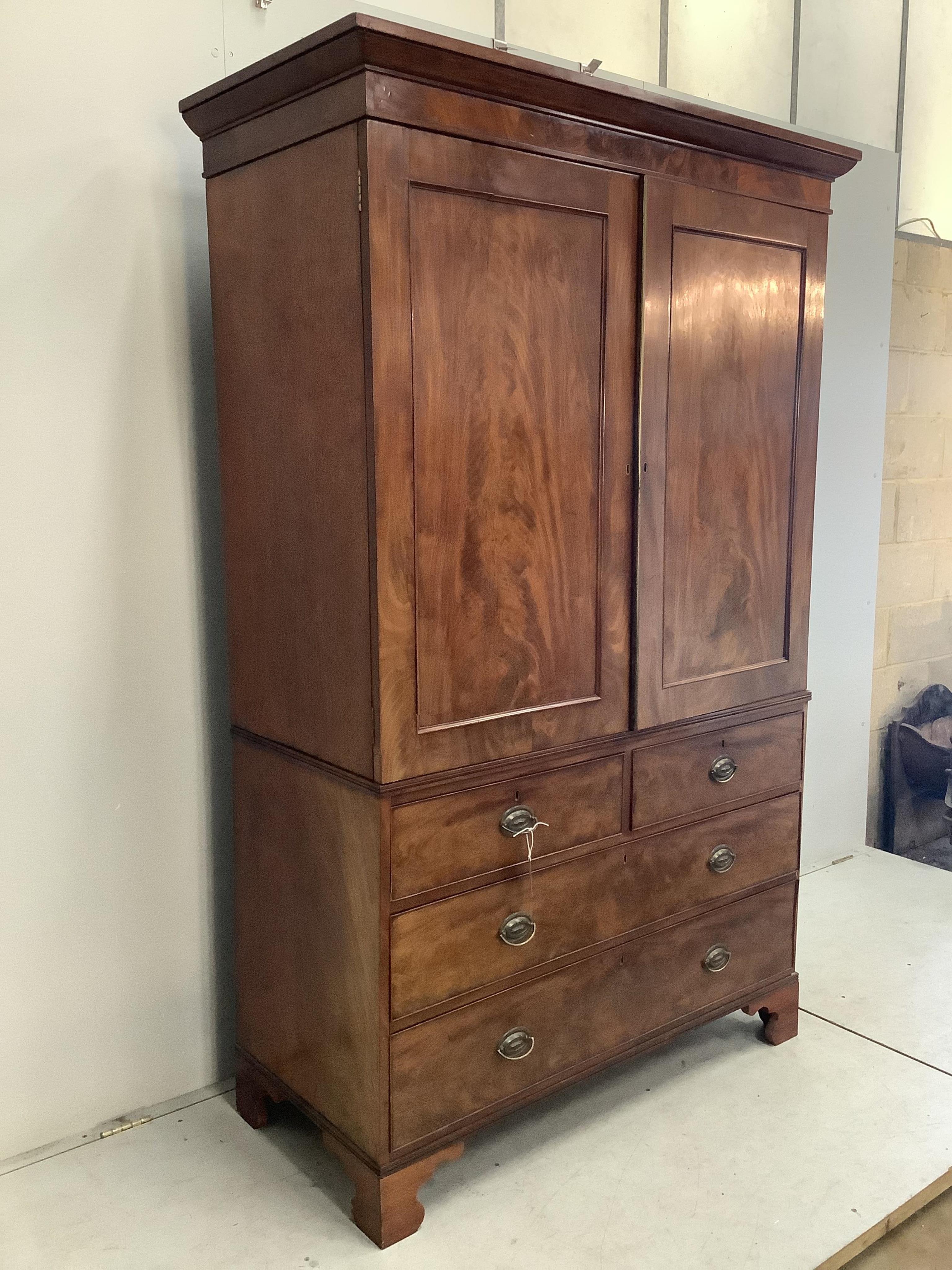 A George III mahogany linen press converted to a hanging wardrobe, width 130cm, depth 58cm, height 206cm. Condition - fair